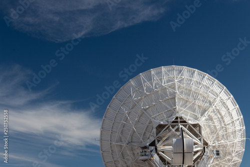Very Large Array back view of a radio astronomy observatory dish against a blue sky, copy space, horizontal aspect