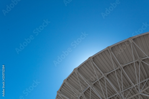 Very Large Array backlit curve of radio astronomy observatory dish in clear sky, science technology space exploration, horizontal aspect