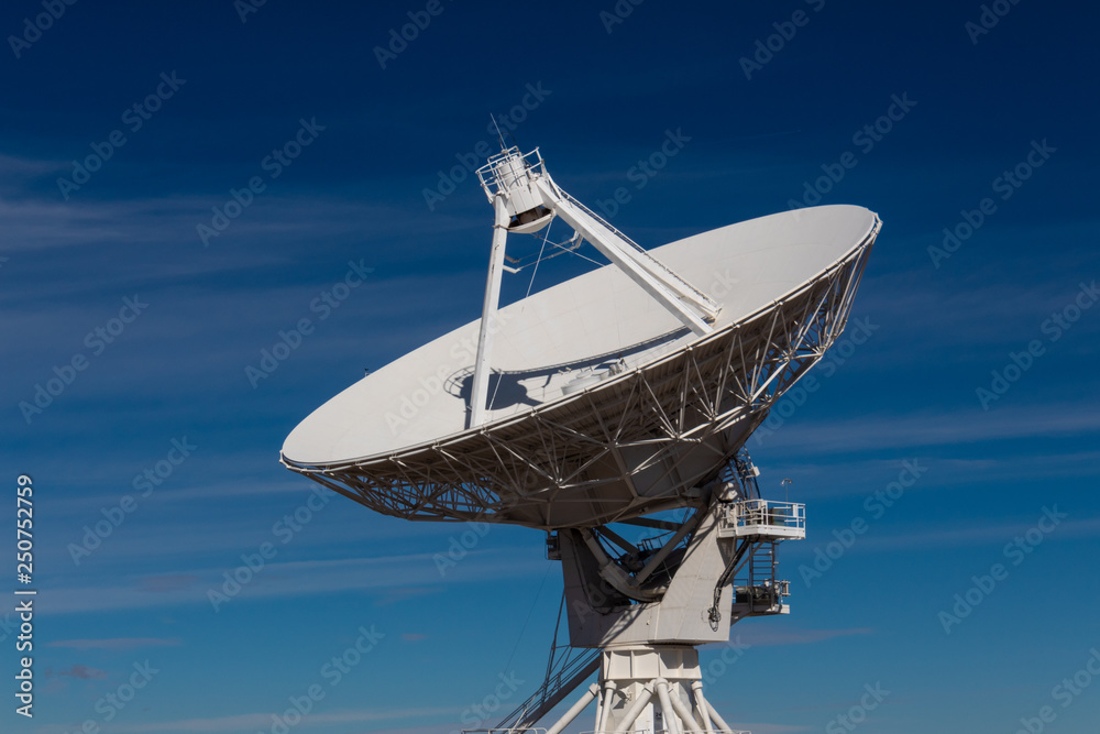 Very Large Array centered view of VLA radio antenna dish isolated against a deep blue sky, horizontal aspect Very Large Array centered view of VLA radio antenna dish isolated against a deep blue sky, horizontal aspect