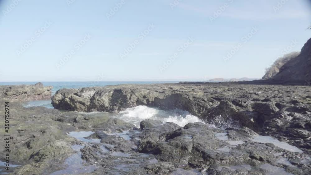Wide slomo shot of turbulent ocean waves crashing onto a rocky sea shore Wide slomo shot of turbulent ocean waves crashing onto a rocky sea shore