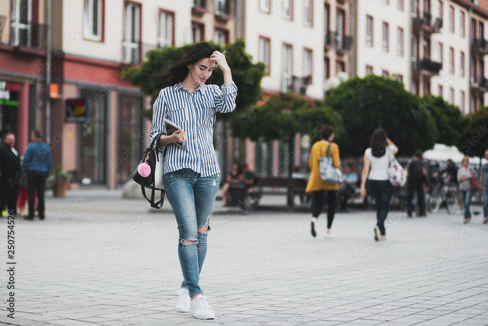 Young brunette woman walking and relaxing in old city street Young brunette woman walking and relaxing in old city street