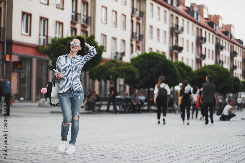 Young brunette woman walking and relaxing in old city street