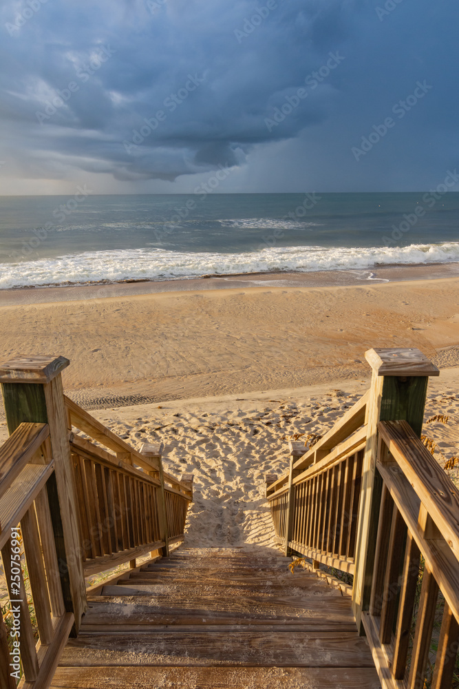 Wooden steps leading to the beach with ocean waves
