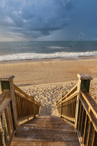 Obraz na płótnie Wooden steps leading to the beach with ocean waves w salonie