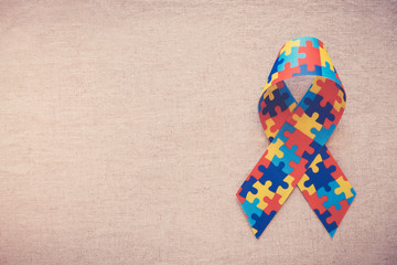 Hands holding puzzle ribbon for World Autism Awareness Day