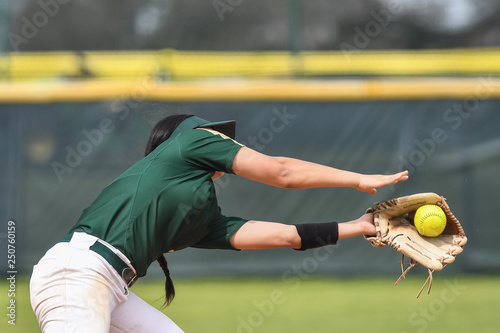 Obraz na płótnie Girls in action playing in a softball game
