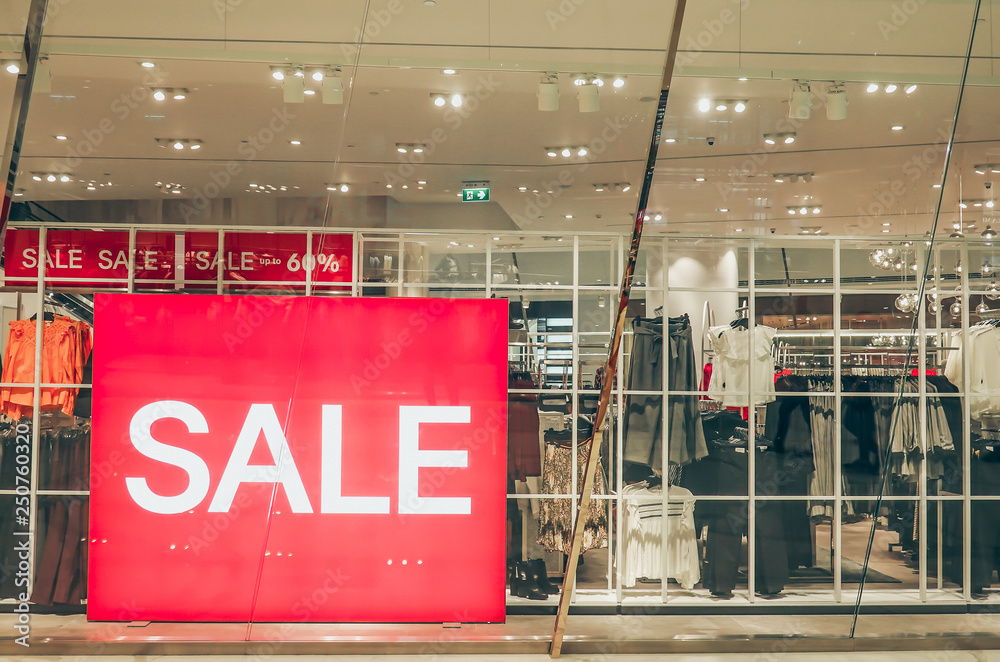 Foto Stock Sales promotion of women fashion clothes retail store in  shopping mall, sale label sign sticker in front of shop door glasses.. |  Adobe Stock