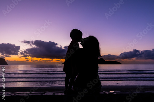 silhouette of family watching sunset at the beach in ranong