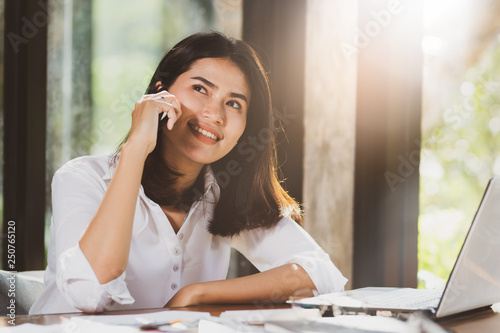 Asia woman using laptop computer ,smartphone working in office with relax fun and happy. photo