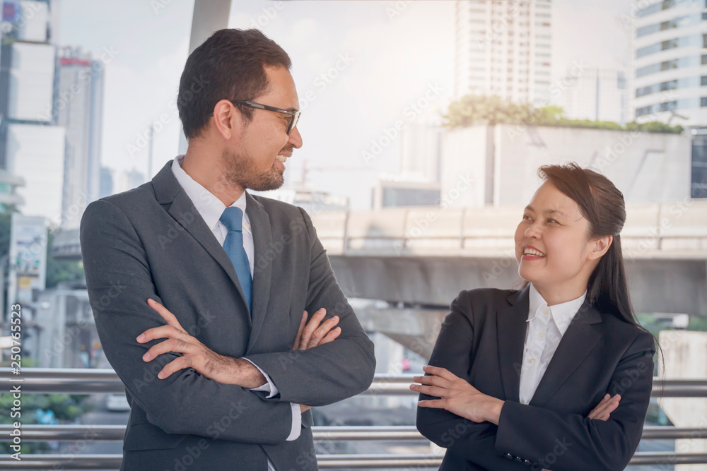 Two business people smile in an urban environment Two business people smile in an urban environment