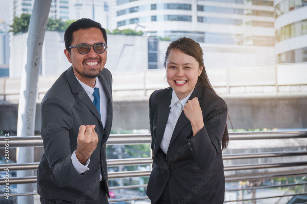 Two business people smile in an urban environment that lifted his hand and delighted with success Two business people smile in an urban environment that lifted his hand and delighted with success