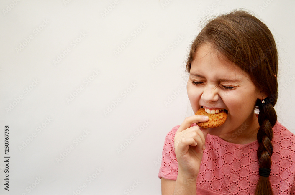 the girl stands on a light background with oatmeal cookies in her hands the girl stands on a light background with oatmeal cookies in her hands