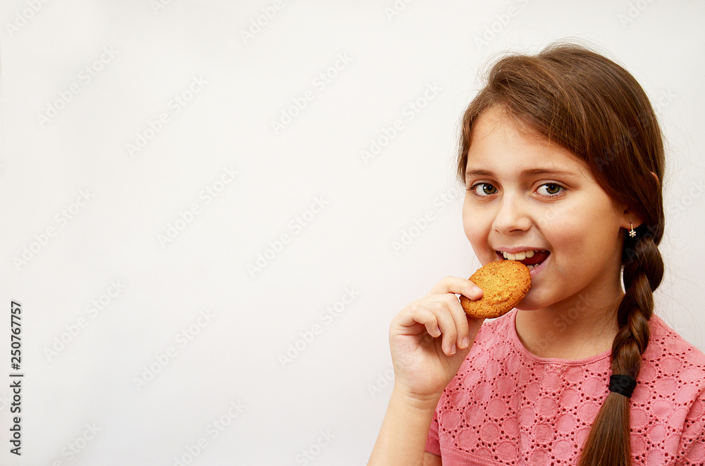 the girl stands on a light background with oatmeal cookies in her hands the girl stands on a light background with oatmeal cookies in her hands