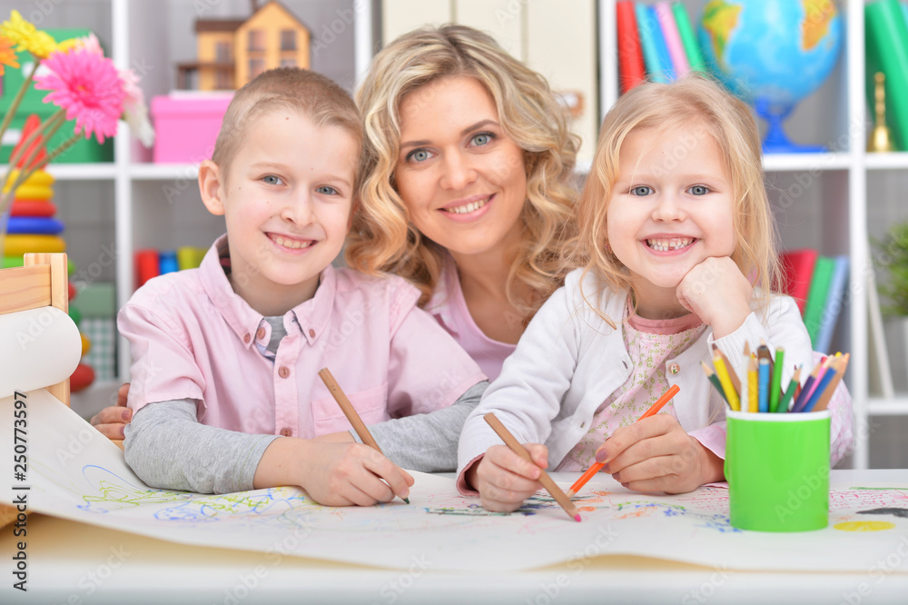 Fototapeta premium Beautiful mother with daughter drawing with colorful pencils