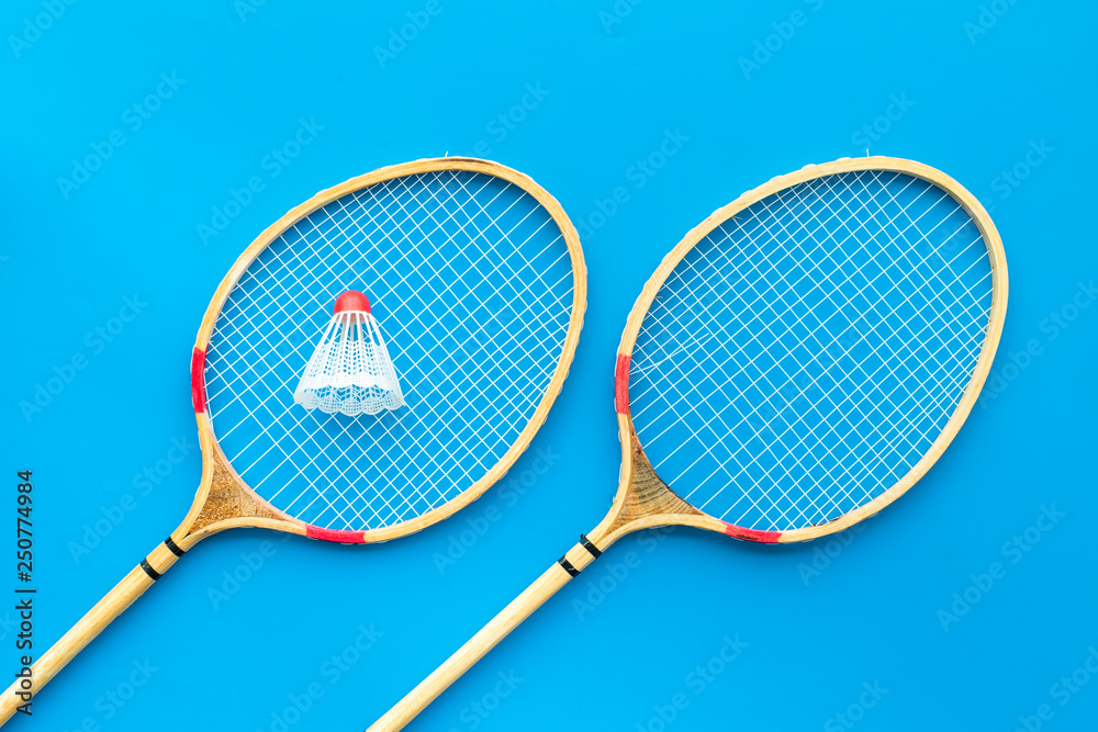 Badminton concept. Badminton rackets and shuttlecock on blue background top view pattern