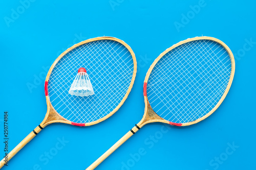 Badminton concept. Badminton rackets and shuttlecock on blue background top view pattern © 9dreamstudio