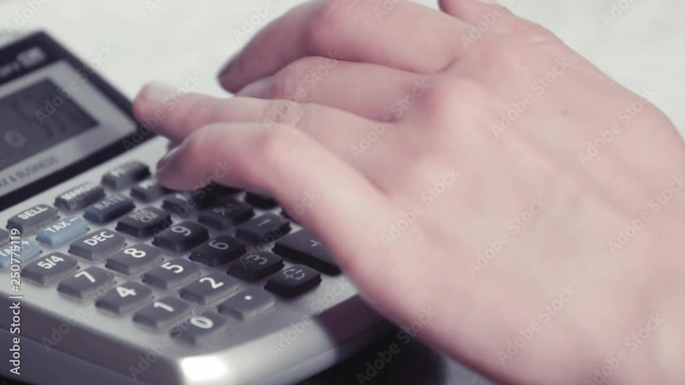 Woman fingers counting with a calculator Woman fingers counting with a calculator
