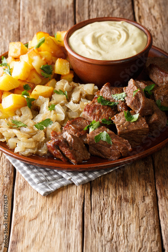 Swedish recipe pyttipanna for beef rydberg with stewed onions and fried potatoes with mustard sauce close-up on a plate. vertical photo