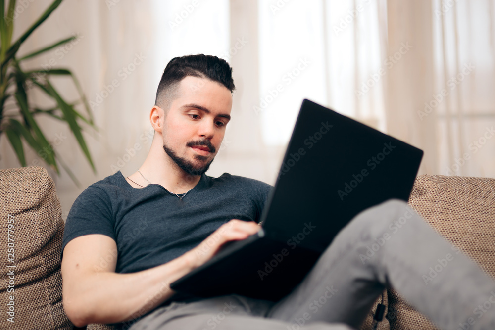 Man Sitting on a Couch Using His Laptop Man Sitting on a Couch Using His Laptop