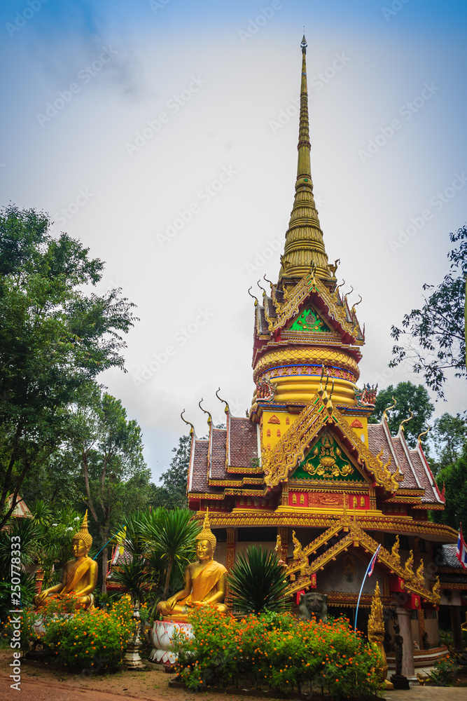 Beautiful golden pagoda with decorative Thai style fine art at public Buddhist Wat Phu Phlan Sung temple, Nachaluay, Ubon Ratchathani, Thailand.