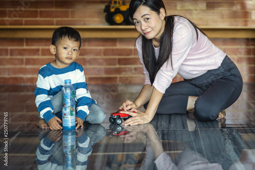 Asian single mom with son are playing with car toy together when living in modern house for Self learning or home school, Family and single mom concept, selective focus