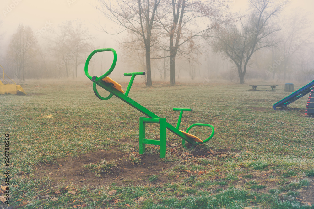 Empty children's playground on a foggy autumn morning
