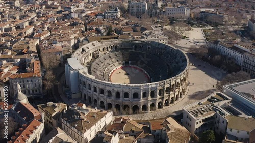 Aerial view flying around the Arena of Nîmes a roman amphitheatre during winter sunny day 