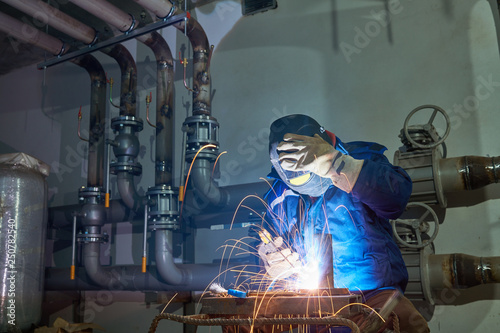 Welder worker at industrial arc welding work