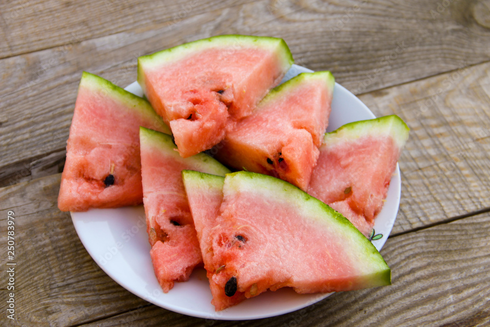 Sliced watermelon in a plate on wooden table