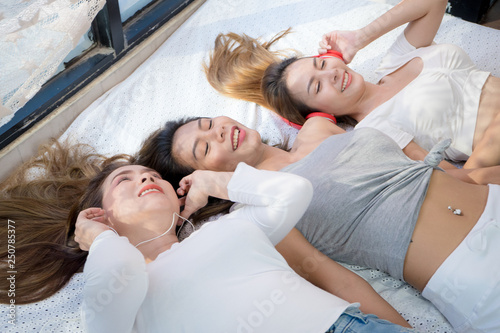 Cute girl group are funny happy and relax on the bed, Womans are happy from listen music on the bed