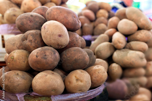 Dry potato tubers on the background of various other varieties in the blur.
