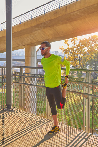 Sportsman working out / jogging on a big city urban bridge.