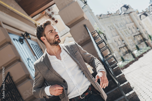 Learn to let go. That is the key to happiness. Serious brown-haired man standing outdoors after a hard day photo