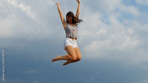 Happy young beautiful woman jumping, blue sky background. 180 fps