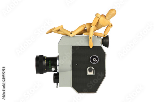 Wooden model of man lies on old movie camera