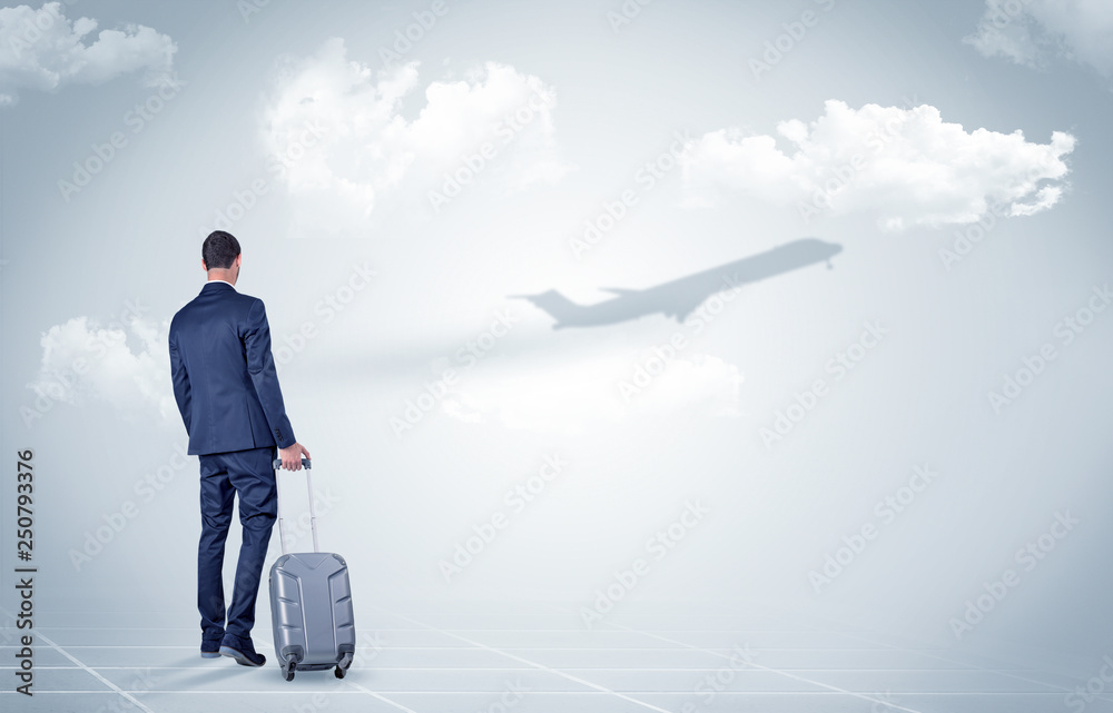Young businessman with luggage walking towards an looking to a raising airplane
Young businessman with luggage walking towards an looking to a raising airplane