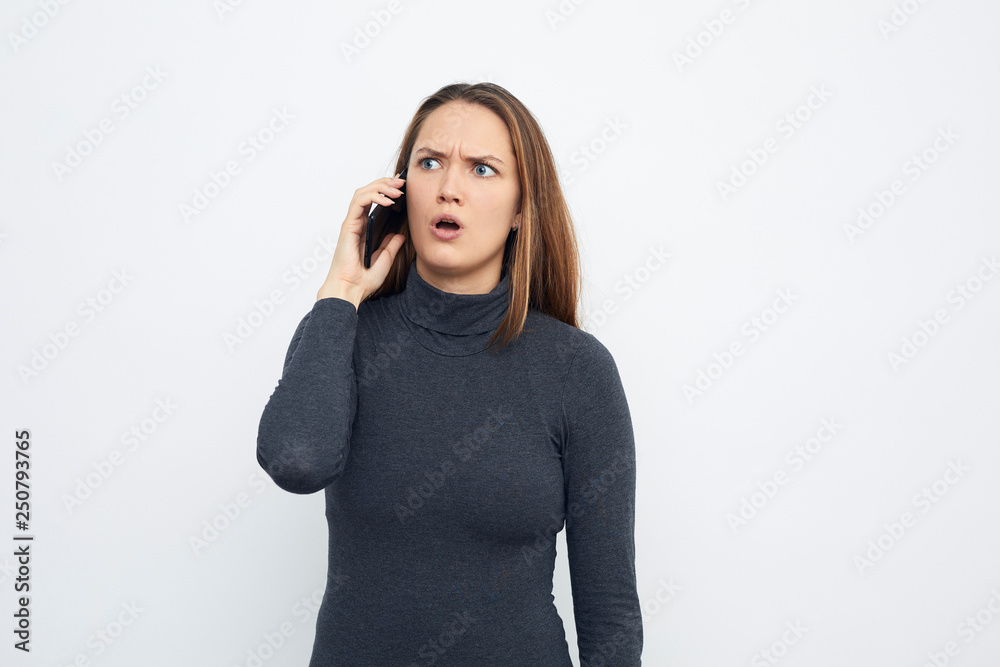 young woman talking on mobile phone isolated on white skeptical young woman talking on mobile phone isolated on white skeptical