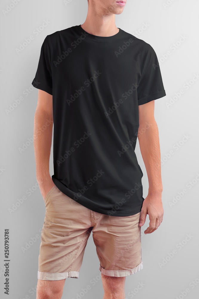 Obraz premium Young slim caucasian man in a black T-shirt on a white studio background.