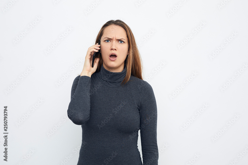 young skeptical woman talking on mobile phone young skeptical woman talking on mobile phone