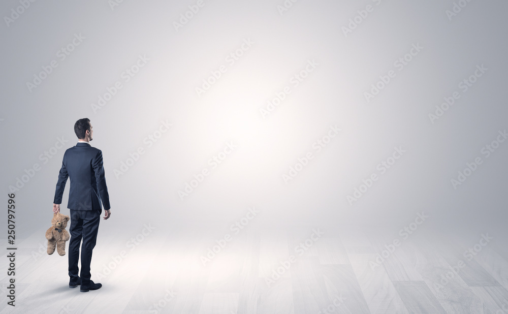 Man standing with his back in an empty room with object in his hand Man standing with his back in an empty room with object in his hand