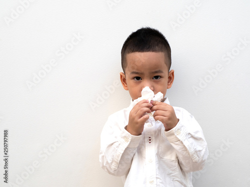 sick asian boy blow his nose into tissue
