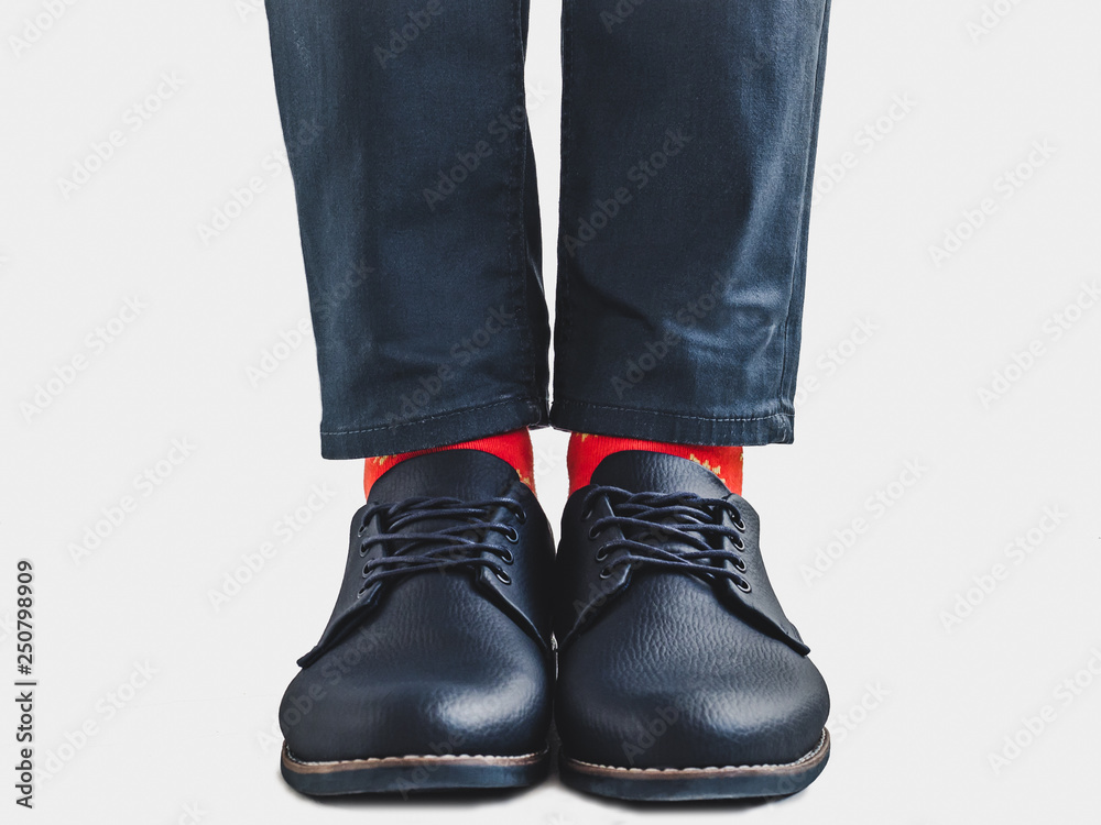 Office Manager in stylish shoes, blue pants and bright, colorful socks on a white, isolated background. Close-up. Style, fashion, beauty, elegance