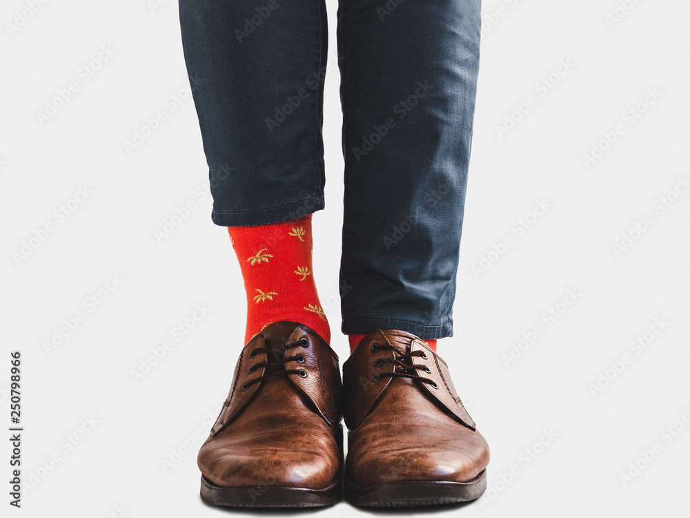 Office Manager in stylish shoes, blue pants and bright, colorful socks on a white, isolated background. Close-up. Style, fashion, beauty, elegance