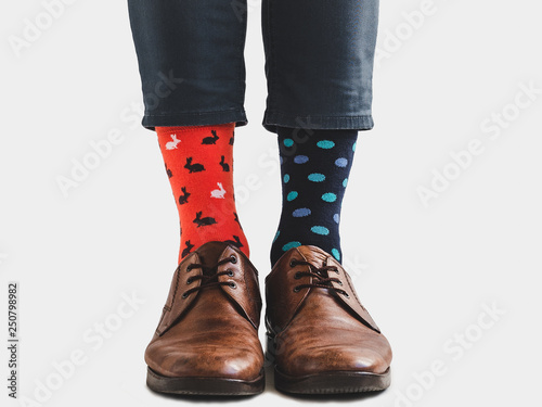 Office Manager in stylish shoes, blue pants and bright, colorful socks on a white, isolated background. Close-up. Style, fashion, fun, elegance