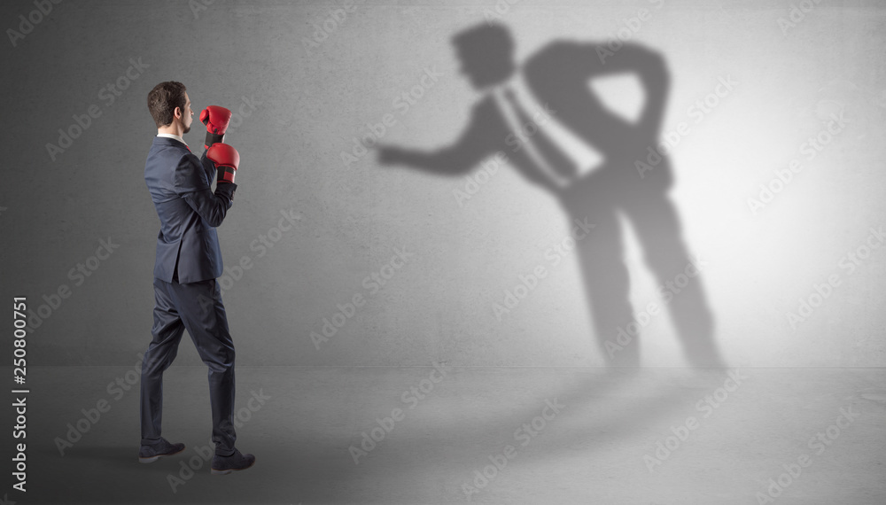 Businessman fighting with his bossy yelling shadow
Businessman fighting with his bossy yelling shadow