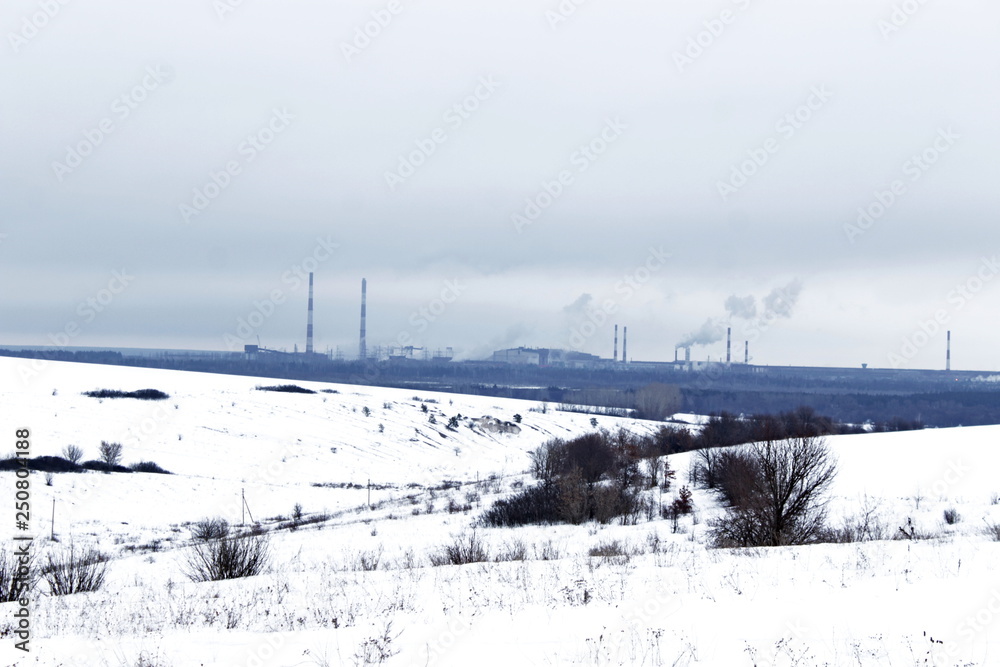pipes of metallurgical plant on a snowy horizon
