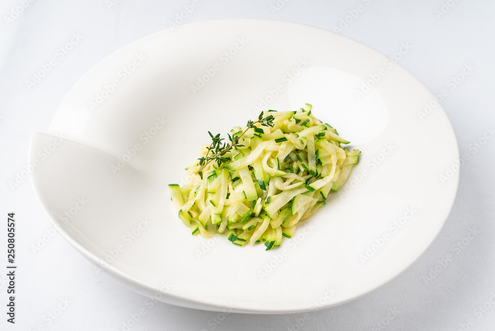 zucchini pasta with thyme on the white plate zucchini pasta with thyme on the white plate