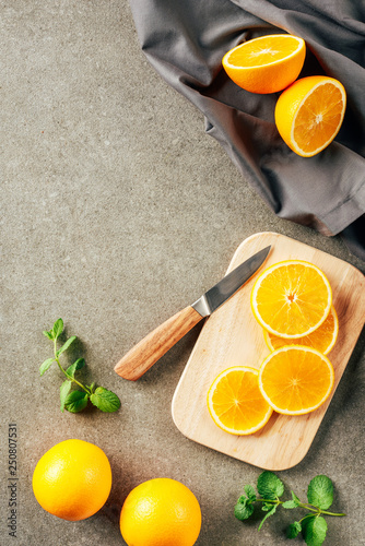 cliced oranges on cutting board with knife and cloth photo