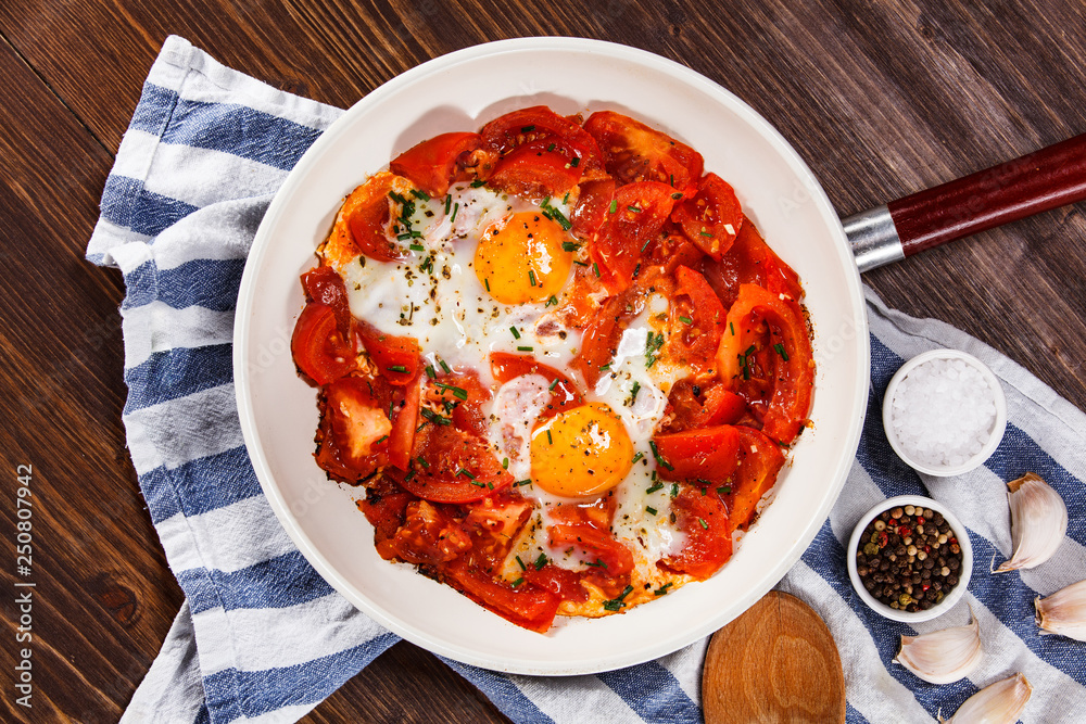 Shakshuka - fried eggs with vegetables in frying pan Shakshuka - fried eggs with vegetables in frying pan