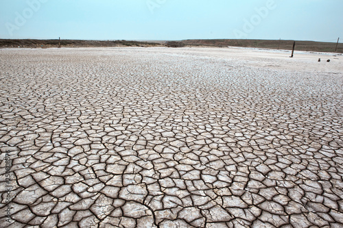 Dried salt lake. Gray dry soil or cracked ground texture background. Takyr.